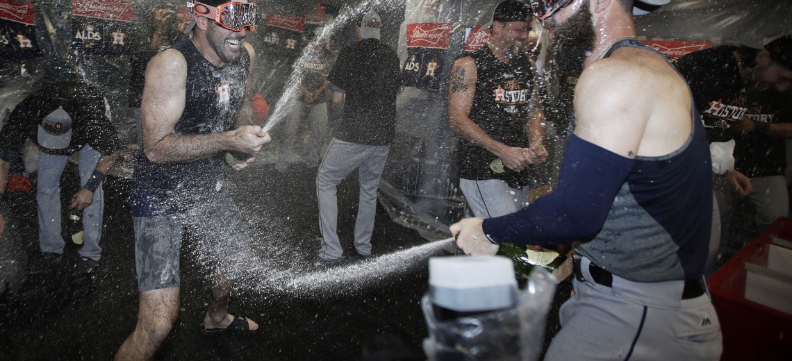 ADDS PLAYER'S NAME - Houston Astros pitcher Justin Verlander, left, celebrates in the clubhouse with teammates after eliminating the Boston Red Sox with a 5-4 victory in Game 4 of baseball's American League Division Series, Monday, Oct. 9, 2017, in Boston. (AP Photo/Charles Krupa)